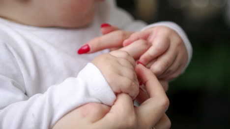 caring mother with baby, concept of love and family. hands of mother and baby closeup, hand in hand. mother care. playing with baby at home. slow motion