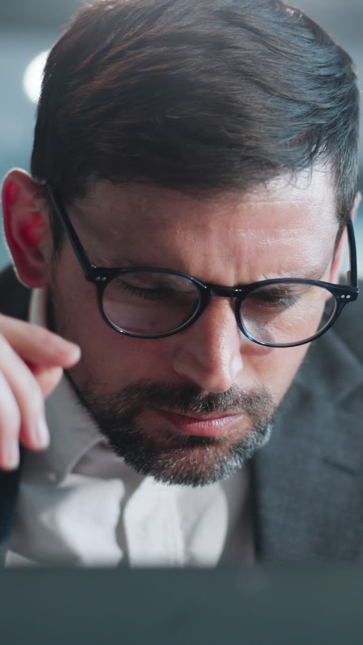 Professionista con gli occhiali che li sistema mentre lavora