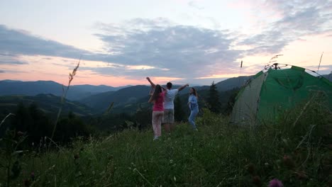 friends have fun near the tent in the mountains young tourists have fun near the tent in the mountains