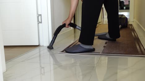 woman vacuuming a hallway