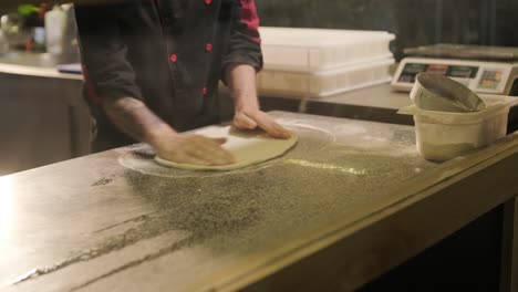 chef preparing pizza toppings in a restaurant kitchen