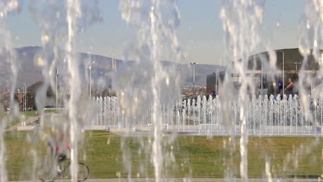 fountains and cityscape in zagreb capital of croatia in slow motion with red biker on a bicycle pasing trough