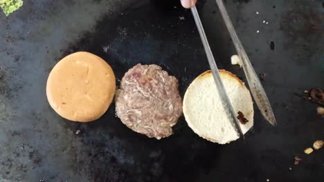 top shot of a chef's hands turning grilled corned beef and bread on a grate