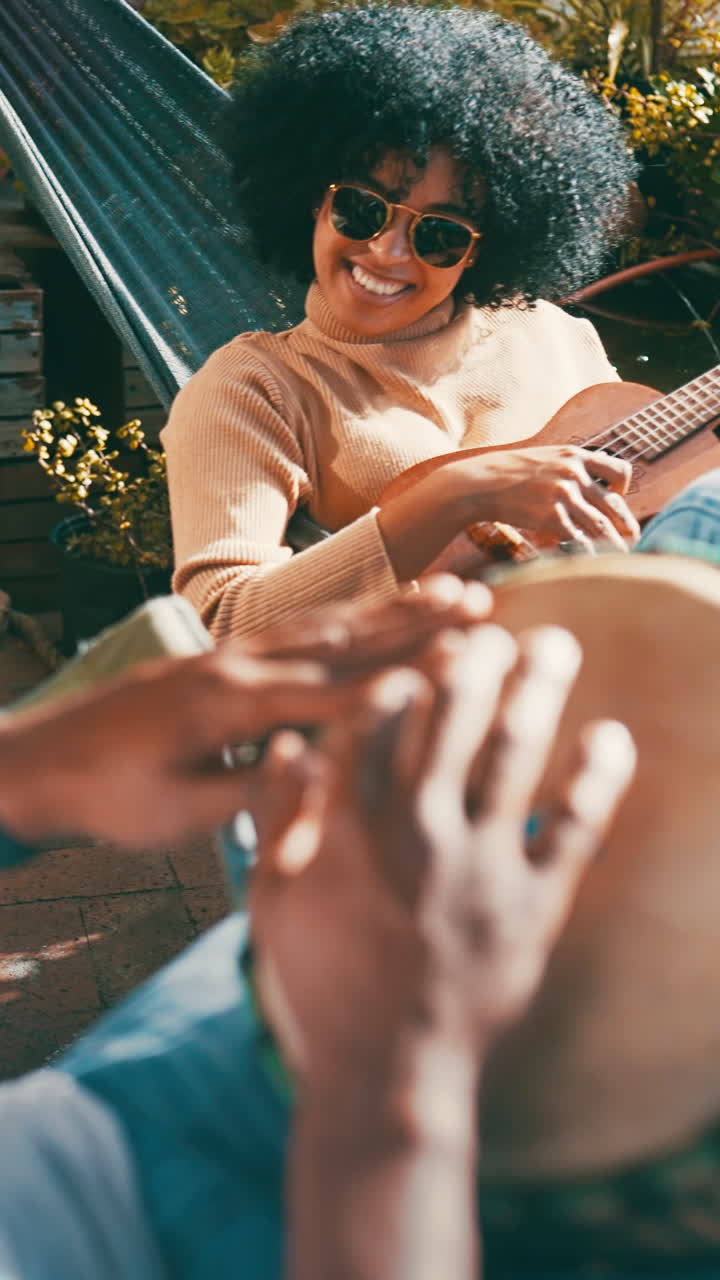 Donna felice che suona l'ukulele con un'amica che suona le percussioni all'aperto