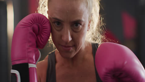 primer plano de una boxeadora con guantes de boxeo practicando sus golpes en el gimnasio