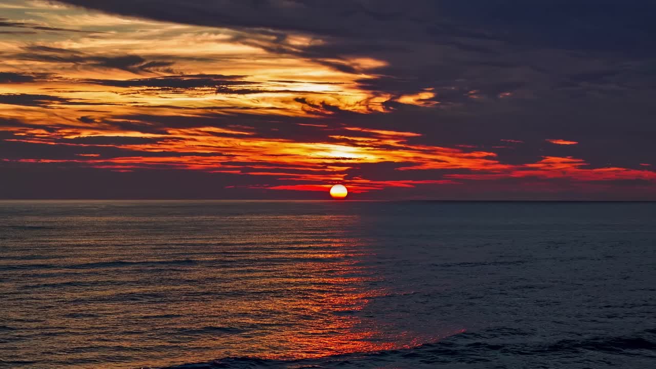 A mesmerizing sunset over the ocean captured from a low-angle, creating a serene and vibrant scene