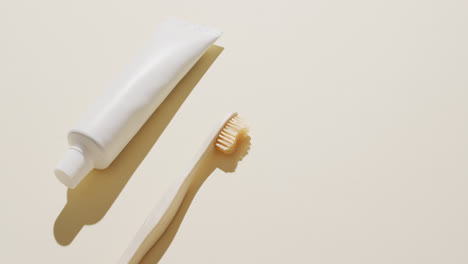close up de pasta de dientes y cepillo de dientes en fondo beige con espacio para copiar