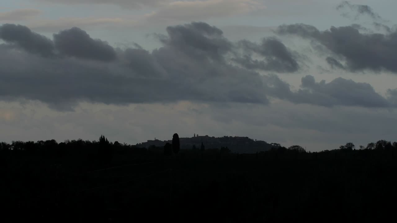 투스카니 풍경의 극적인 저속 촬영, 마을 위를 지나가는 폭풍우 구름