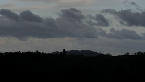 Timelapse-Dramático-Del-Paisaje-En-Toscana,-Nubes-Tormentosas-Pasando-Por-Encima-Del-Pueblo