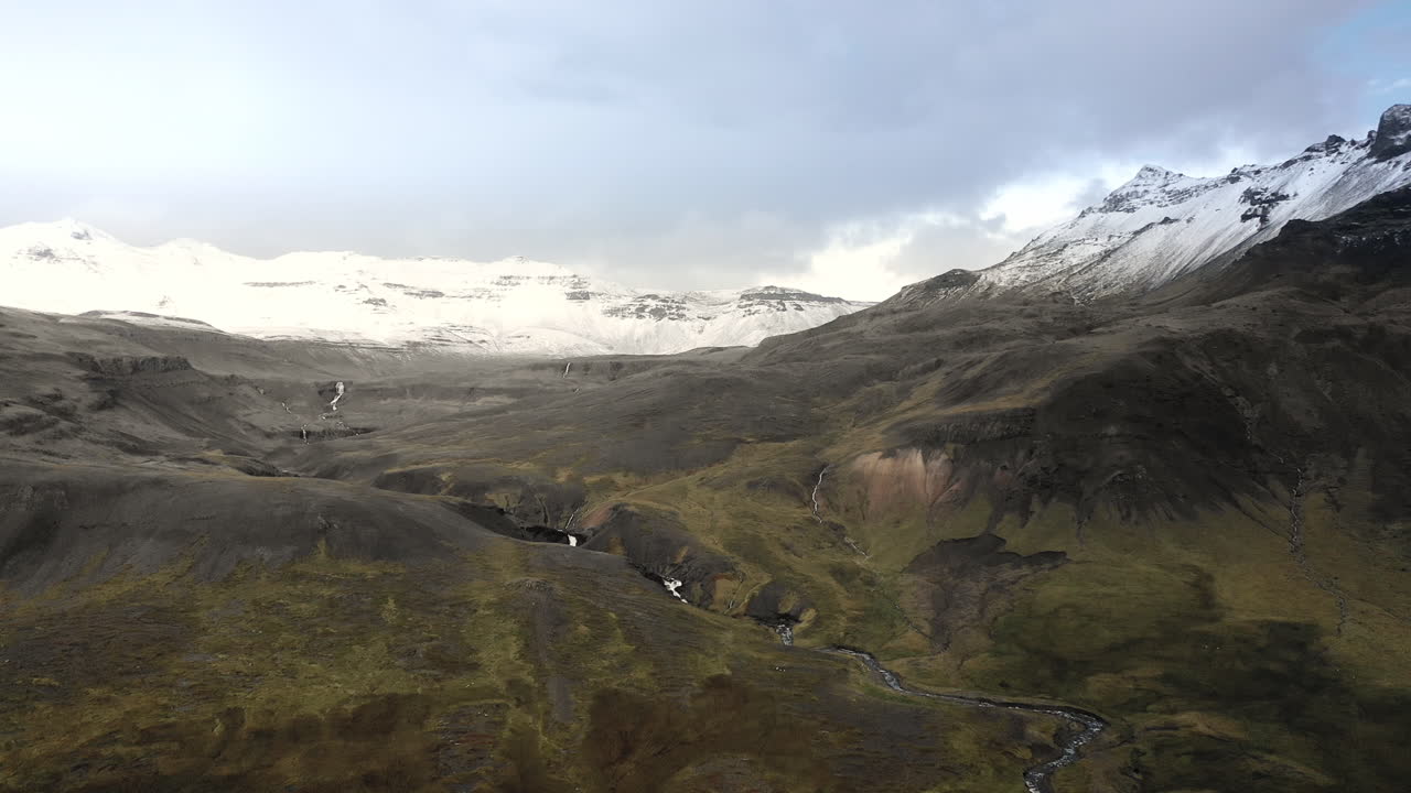 강이 있는 눈 덮인 산의 드론 비행