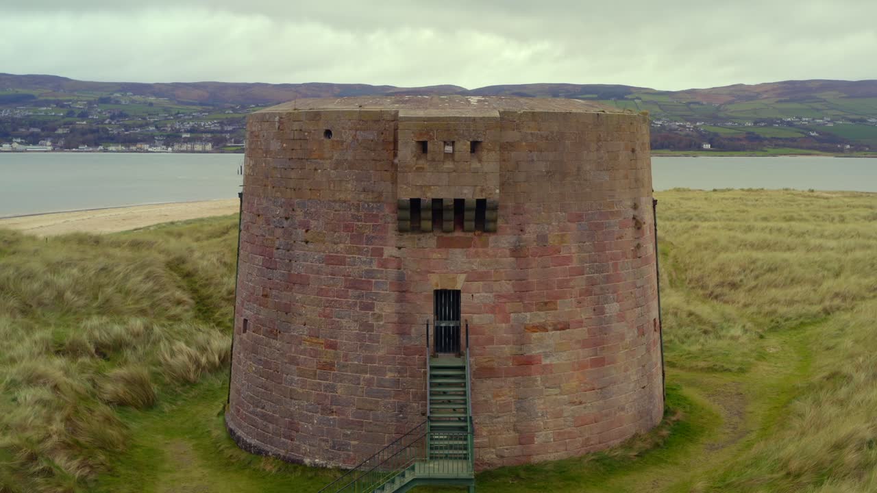 Smooth aerial pullback showcasing the Martello Tower at Magilligan Point, highlighting the entrance of the tower