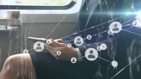 red de iconos de perfil contra la sección media de la mujer de negocios que usa tableta digital en el tren