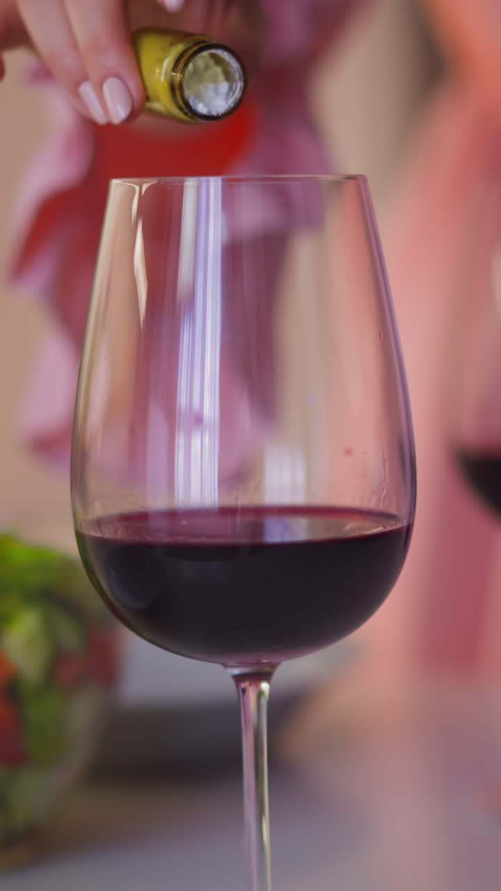 Cruel lady adds deadly poison white powder into hated relative wineglass with red wine to kill and get heritage at home slow motion closeup