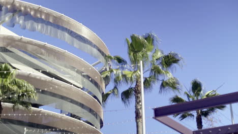 modern building with spiral architectural feature and palm trees