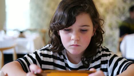 Focused-girl-watching-video-on-smartphone-in-restaurant