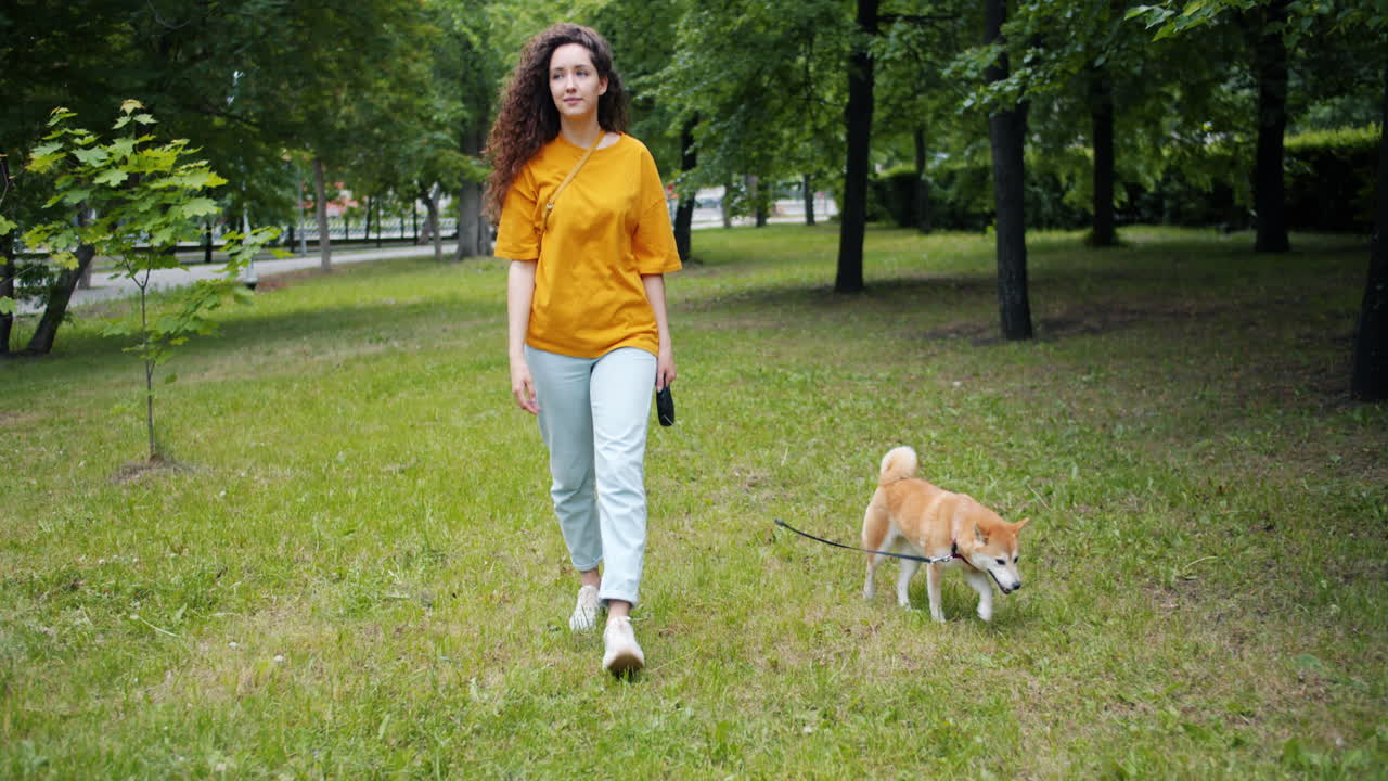 mujer paseando al perro en el parque