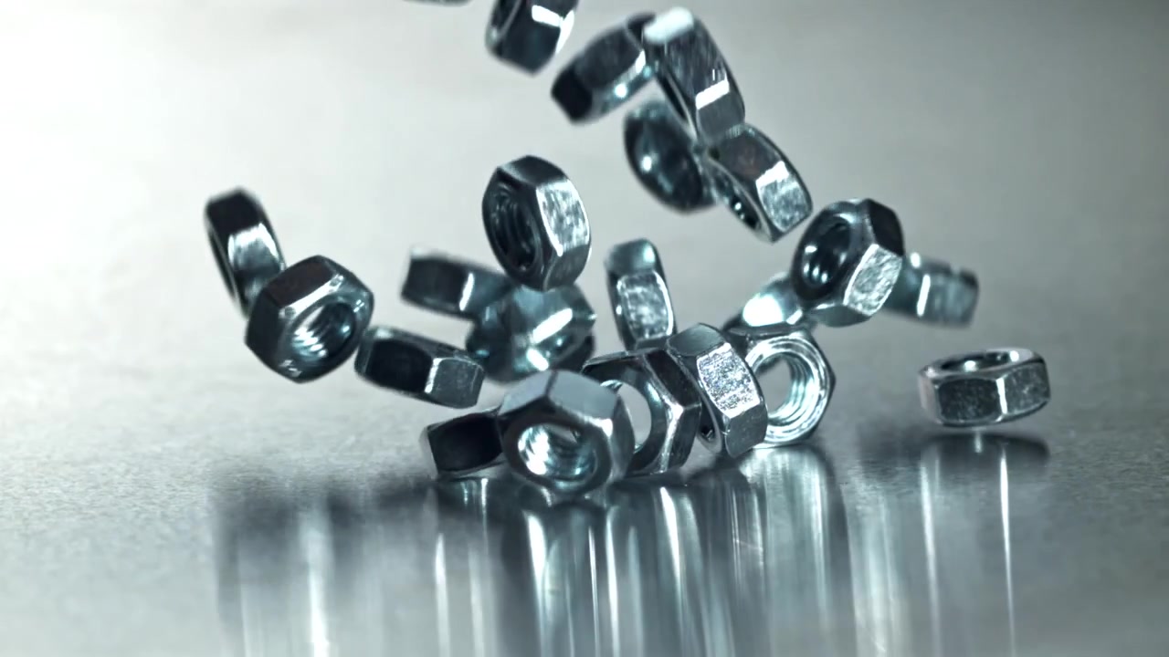 Dadi metallici che cadono e rimbalzano su una superficie riflettente al rallentatore