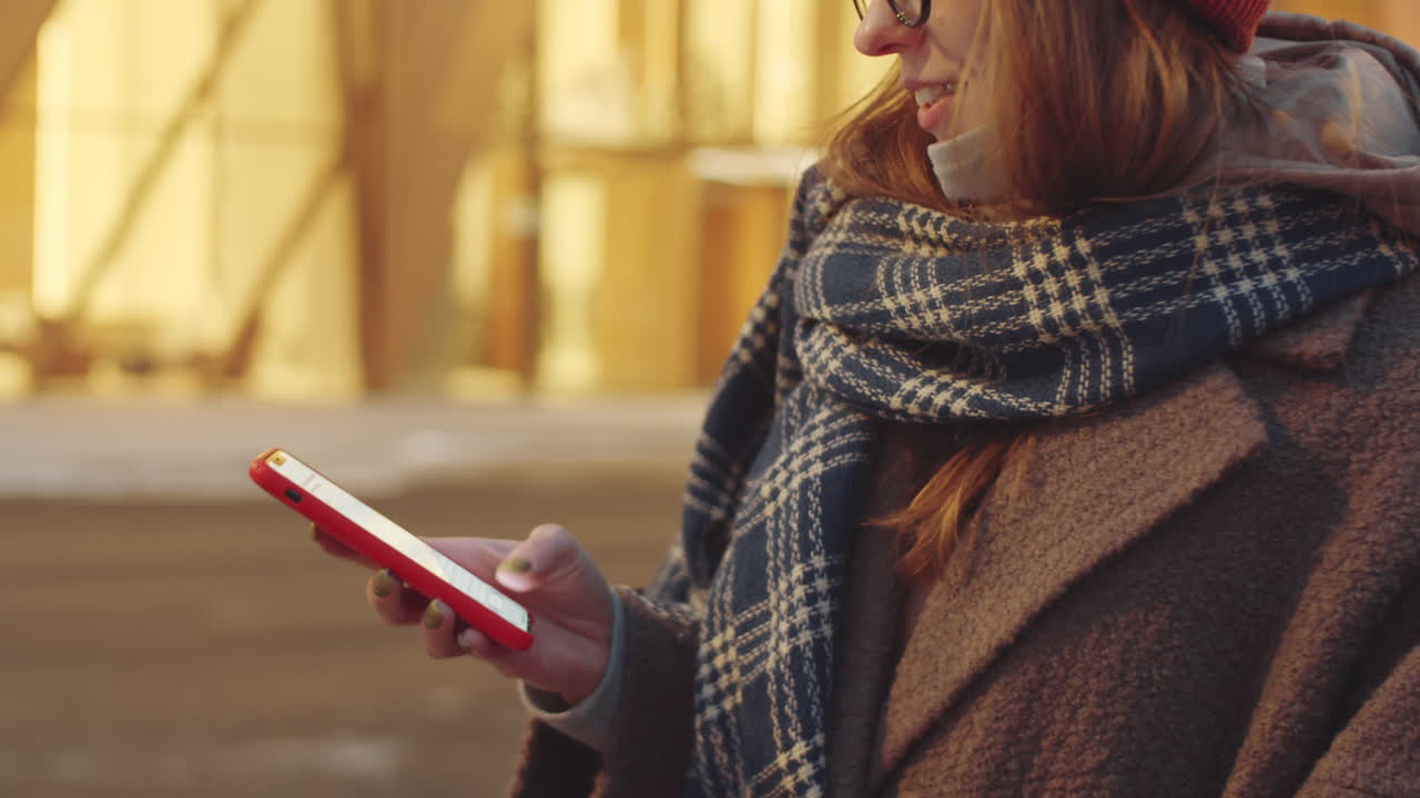 Woman using smartphone outdoors in winter