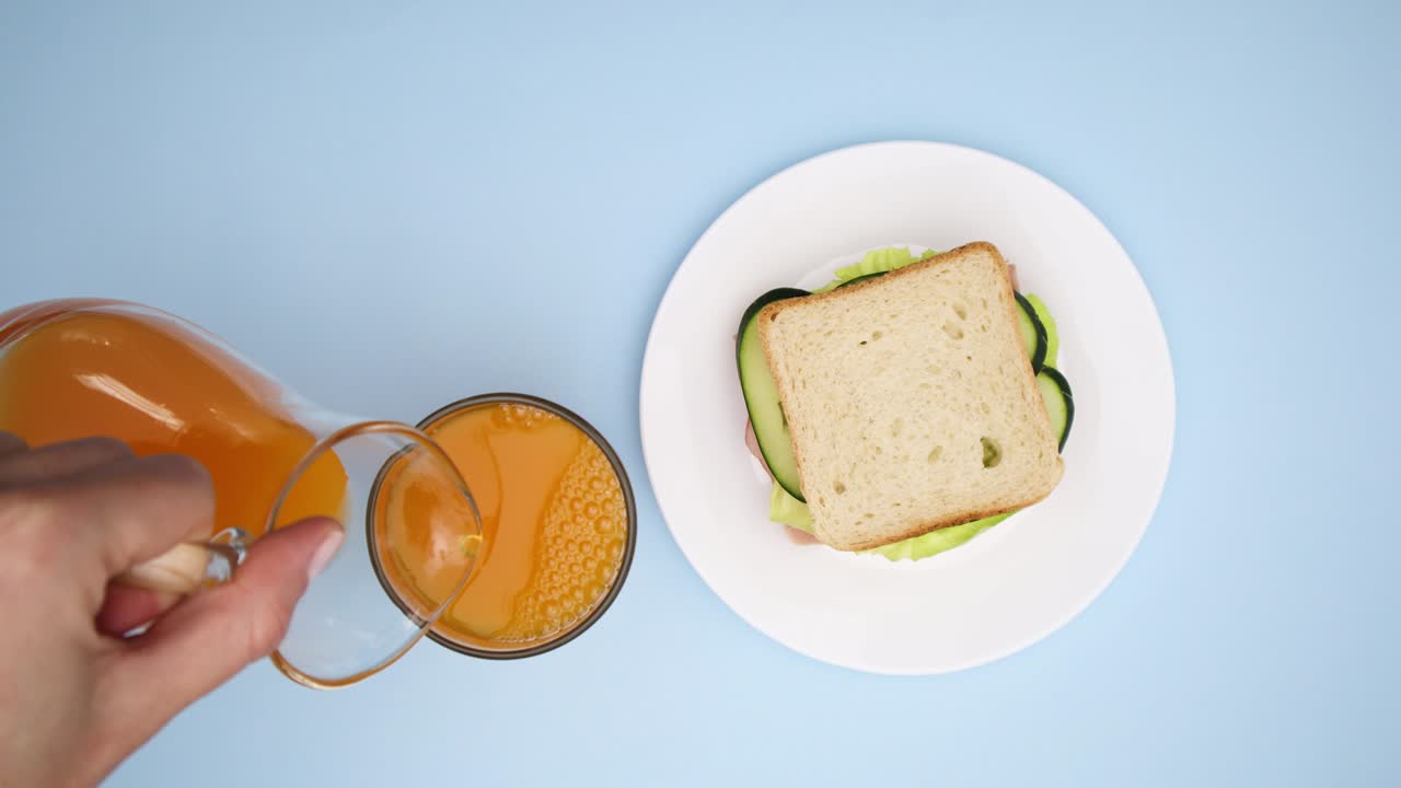 Making sandwich and pouring juice in glass for breakfast - Stop motion
