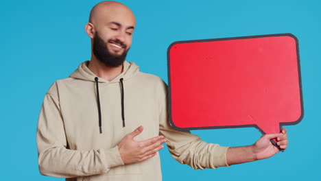 arab person holding red speech bubble icon in studio