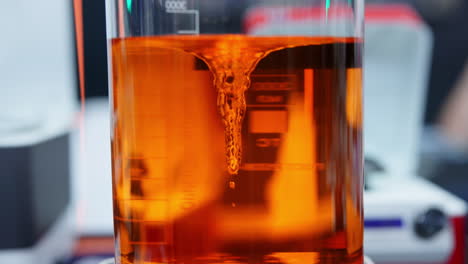 orange liquid stirring in a lab beaker