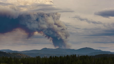 massive plume of smoke from wildfire rises above mountains