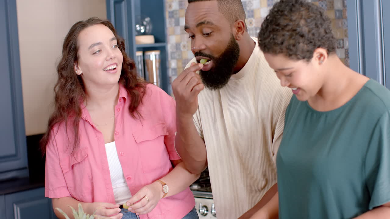 Group of friends cooking together in kitchen, enjoying conversation and laughter