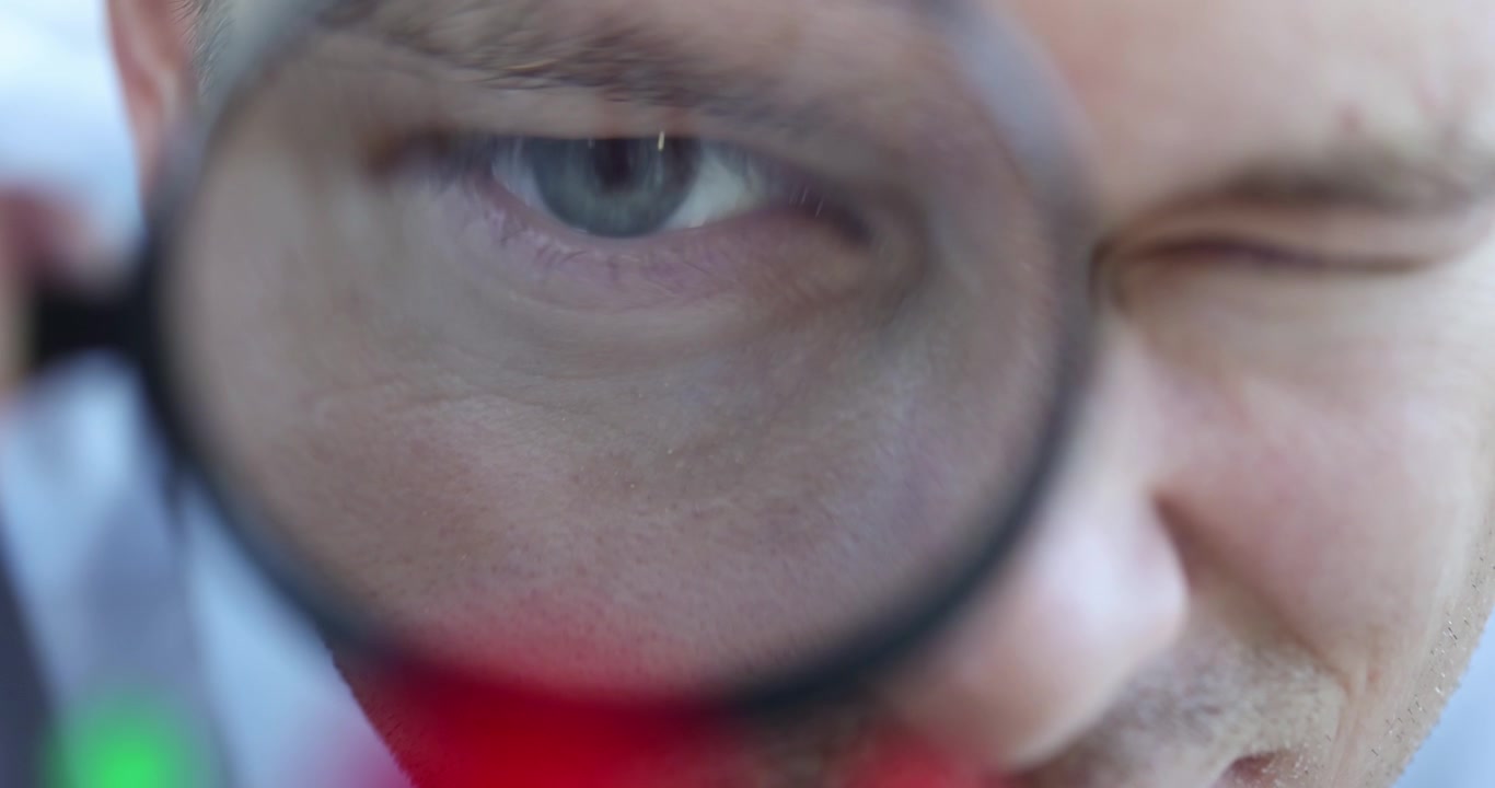 Leder kigger gennem forstørrelsesglas på figurer af mænd nærbillede 4k film i slowmotion