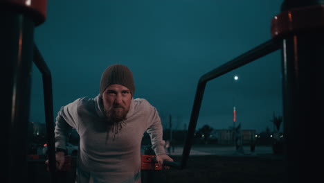 hombre haciendo flexiones al aire libre por la noche