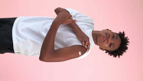 Vertical-video-of-African-teenager-showing-COVID-19-vaccine-bandage-merrily