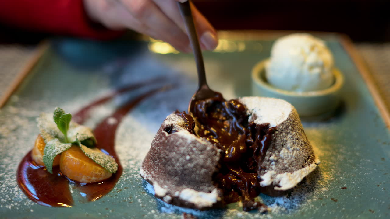 Chocolate lava cake with ice cream and orange decoration in a restaurant