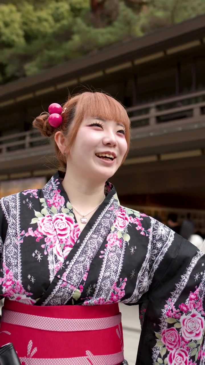 Giovane donna in yukata tradizionale giapponese che visita un tempio