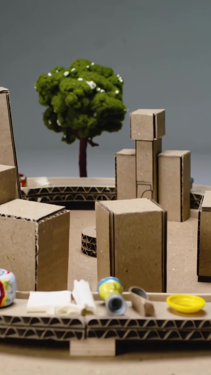 Video verticale: Telecamera che panoramica su un modellino di mini città su un tavolo che mostra torri di cartone