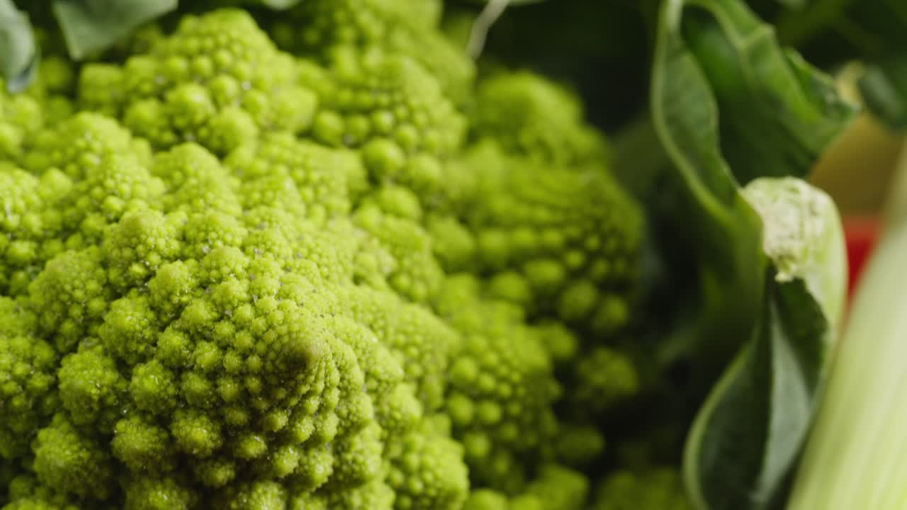 Primo piano di verdure fresche, tra cui broccolo romanesco e cipolla rossa