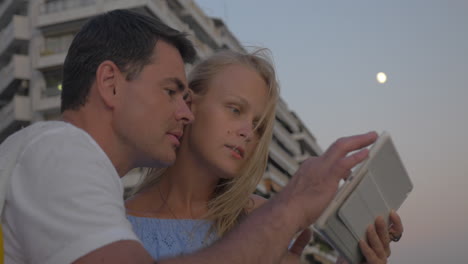 pareja con pad en el paseo marítimo por la noche