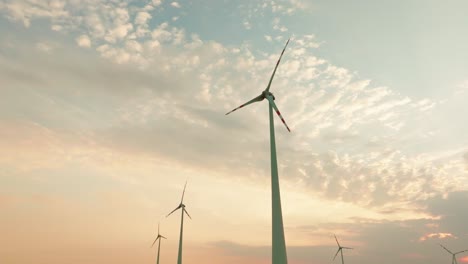 aerial shot of wind turbines spinning gracefully against sunset sky, highlighting renewable energy and environmental sustainability at dusk