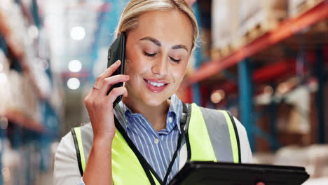 woman worker talking on the phone and using a tablet in a warehouse