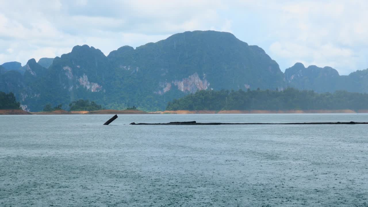 푸른 호수 위에 강한 비가 내리고 초록색 산이 배경으로, 여름 날