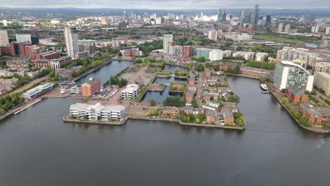 salford quays waterfront district with manchester skyline in background, aerial