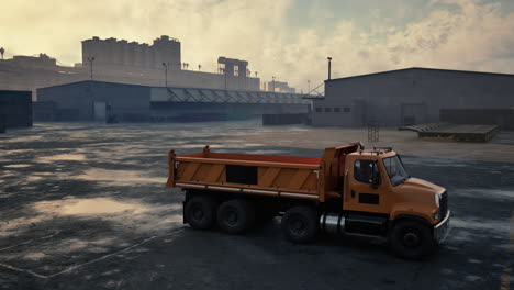un camión de basura amarillo estacionado frente a un gran complejo industrial.