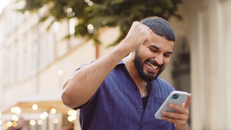 excited man using smartphone