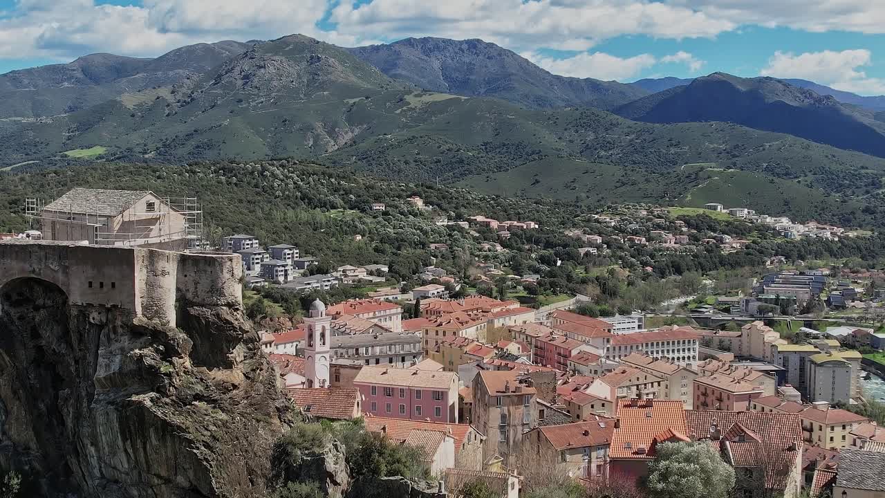 Vista de un pueblo de Córcega con montañas y edificios debajo
