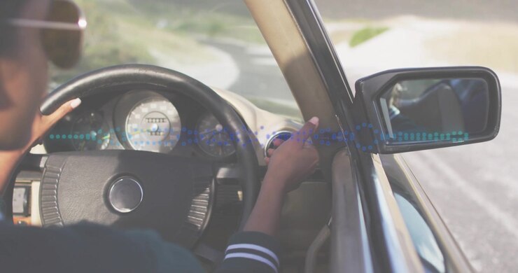 Conducente che si allunga, regola lo specchietto, afferra il volante, mantiene la corsia, con una forma d'onda automatica sovrapposta al cruscotto.