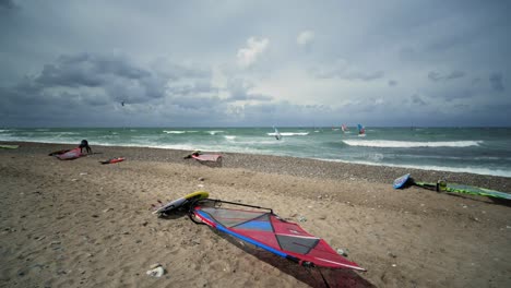 Surfers-at-the-beach-in-summer-with-clouds-and-surfboard-in-the-foreground