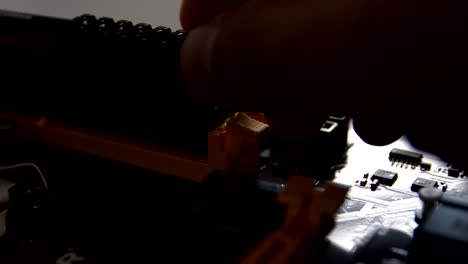 man's hand puts the memory into the motherboard slot