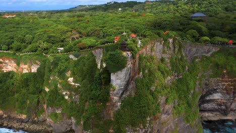 uluwatu temple on the edge of cliff in bali, indonesia - aerial drone shot