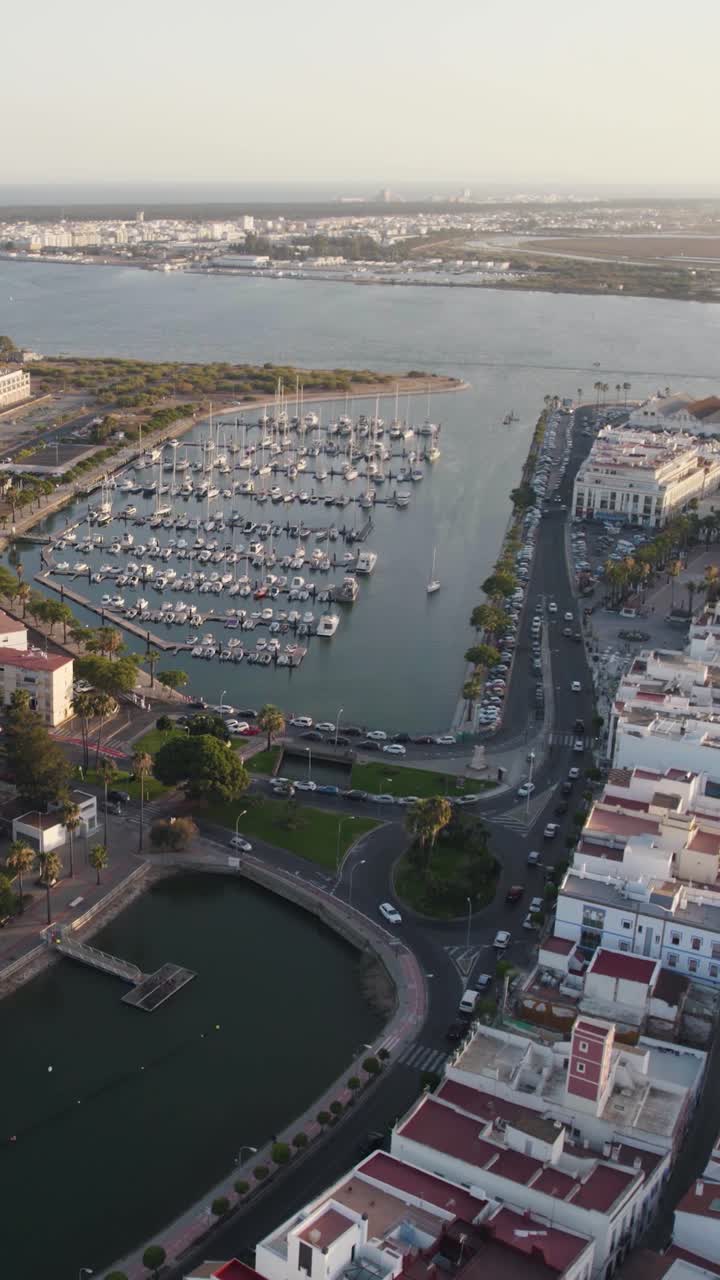 Ripresa aerea verticale che cattura la città di Ayamonte e il paesaggio del porto turistico, con il Portogallo visibile sullo sfondo, al di là del fiume Guadiana