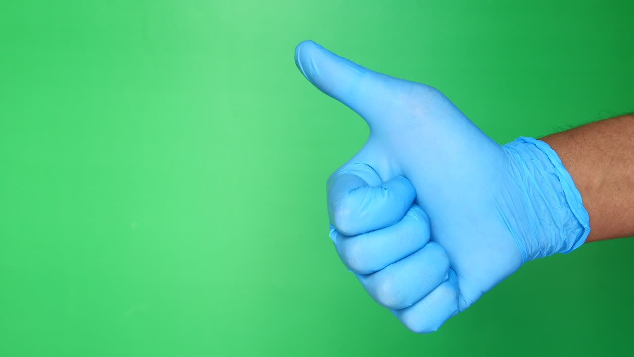 파란 장갑을 입은 사람이 엄지손가락을 올리고