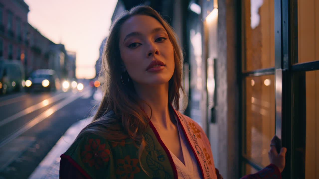 mulher confiante de pé à noite cidade olhando câmera de perto. garota posando cidade