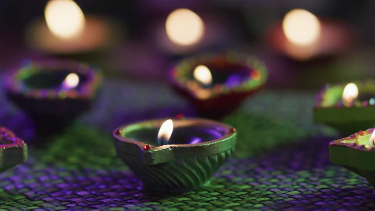 velas encendidas en ollas de arcilla decorativas en alfombra de mesa tejida, enfoque en primer plano, fondo bokeh